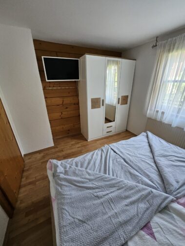 Zimmer mit TV und Kleiderschrank